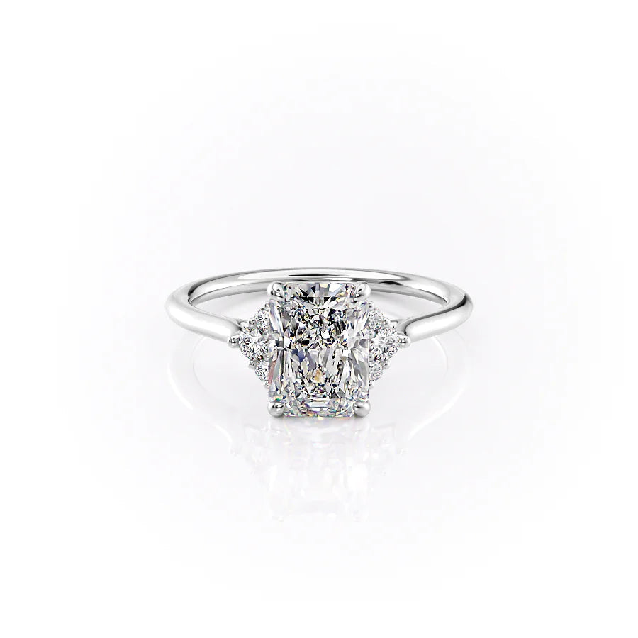 The Victoria. A White Gold Three Stone, Side Stones Engagement Ring Set With A 2ct Radiant Lab Grown Diamond. White Background.