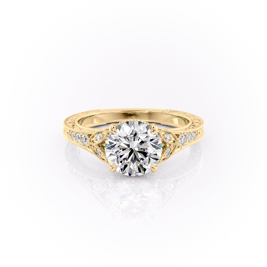 The Violet. A Yellow Gold Vintage, Side Stones Engagement Ring Set With A 2ct Round Lab Grown Diamond. White Background.